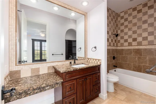 a bathroom with a granite countertop toilet a sink and bathtub