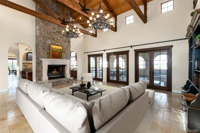 a living room with furniture a fireplace and a chandelier