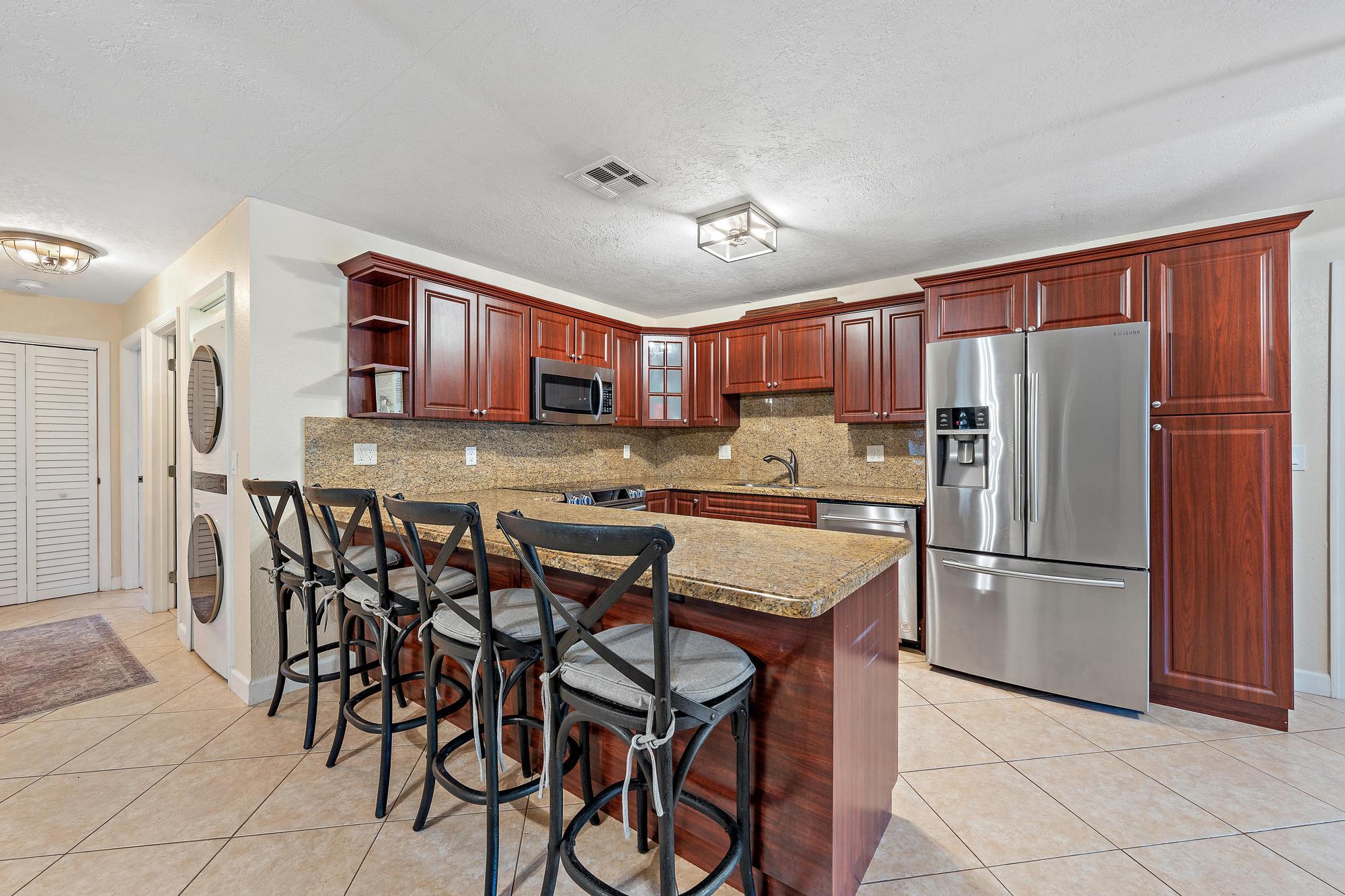 14765 Calusa Trail Palm Beach Gardens, FL 33418 - Photo 13 of 49 a kitchen with stainless steel appliances granite countertop a refrigerator and a stove top oven