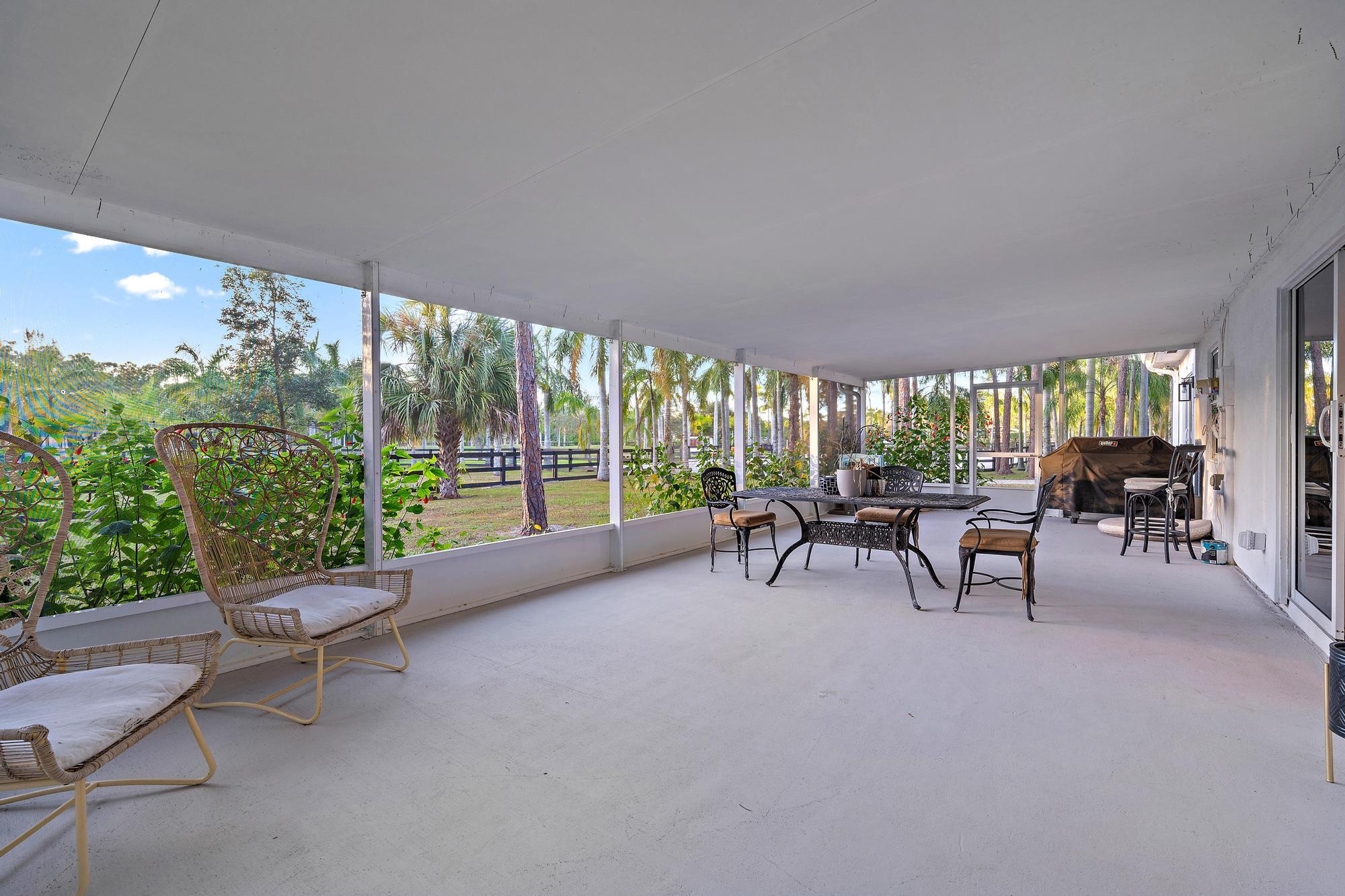 14765 Calusa Trail Palm Beach Gardens, FL 33418 - Photo 22 of 49 a view of a patio with a table and chairs