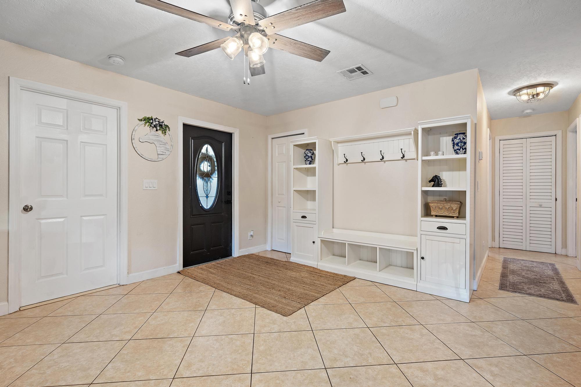 14765 Calusa Trail Palm Beach Gardens, FL 33418 - Photo 10 of 49 a spacious bedroom with a large bed a chandelier and closet