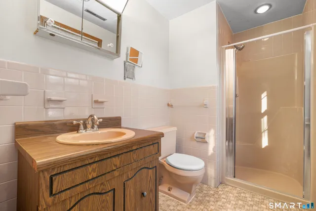 a bathroom with a sink a toilet and shower