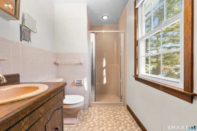 a bathroom with a granite countertop toilet a sink and a shower