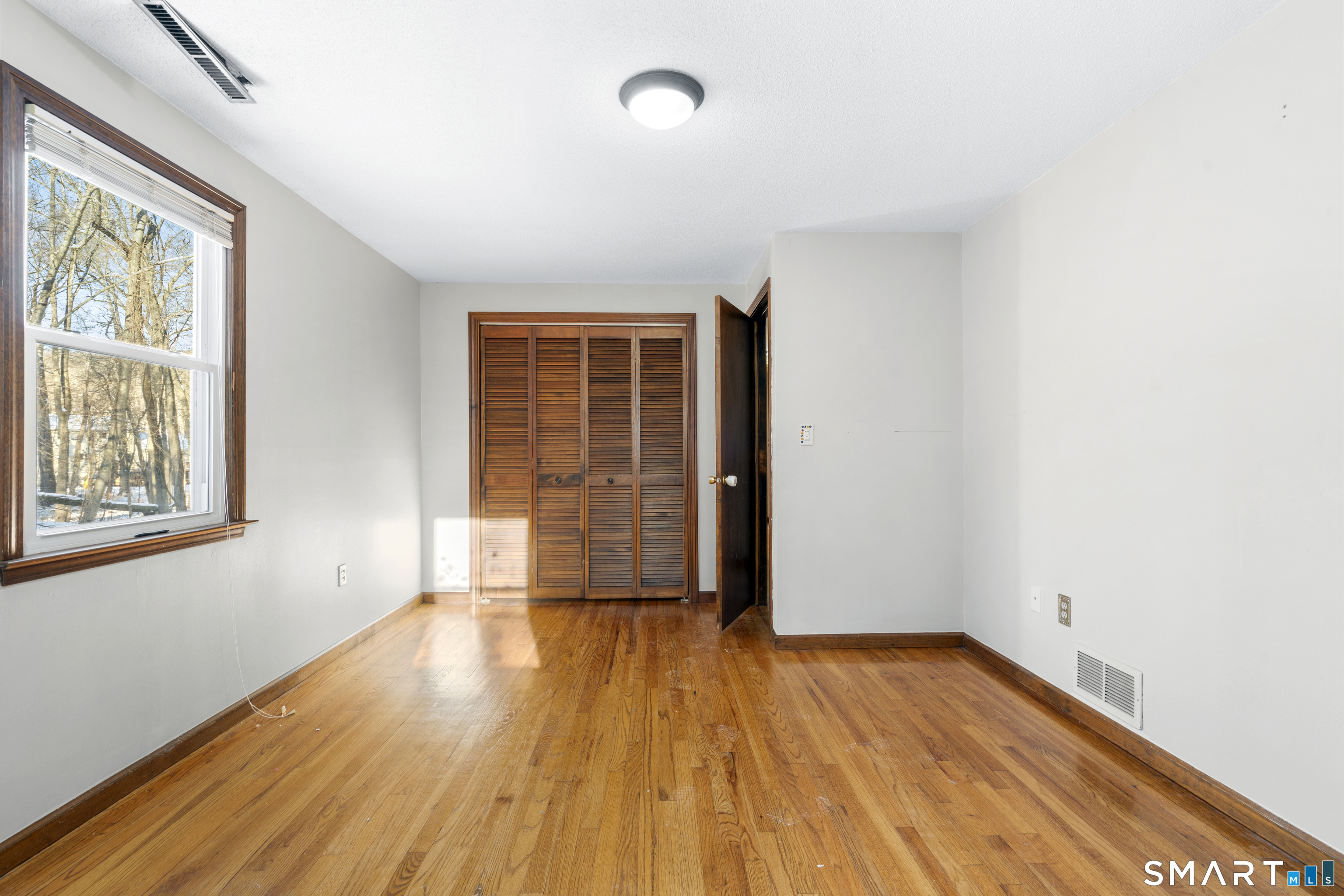 52 Laura Road Hamden, CT 06514 - Photo 20 of 35 an empty room with wooden floor and windows