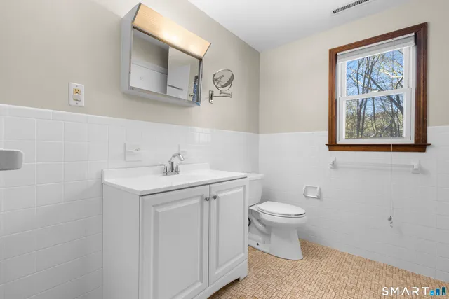 a bathroom with a toilet sink and mirror