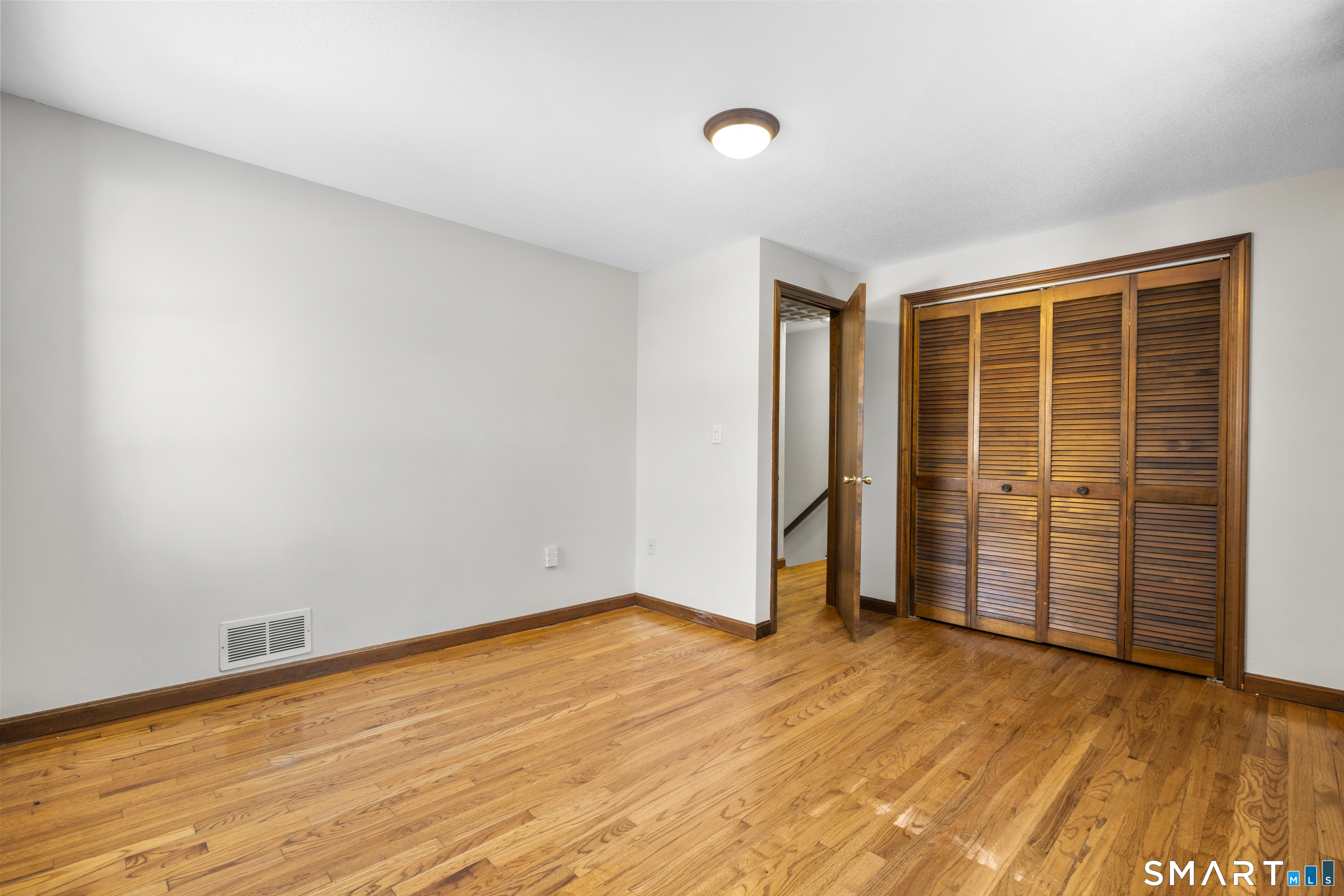 52 Laura Road Hamden, CT 06514 - Photo 26 of 35 an empty room with wooden floor and natural light