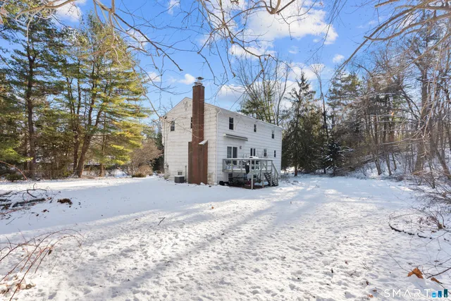 a view of a house with a yard covered in snow
