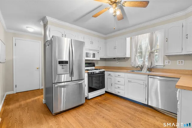 a kitchen with granite countertop stainless steel appliances a sink cabinets and a window