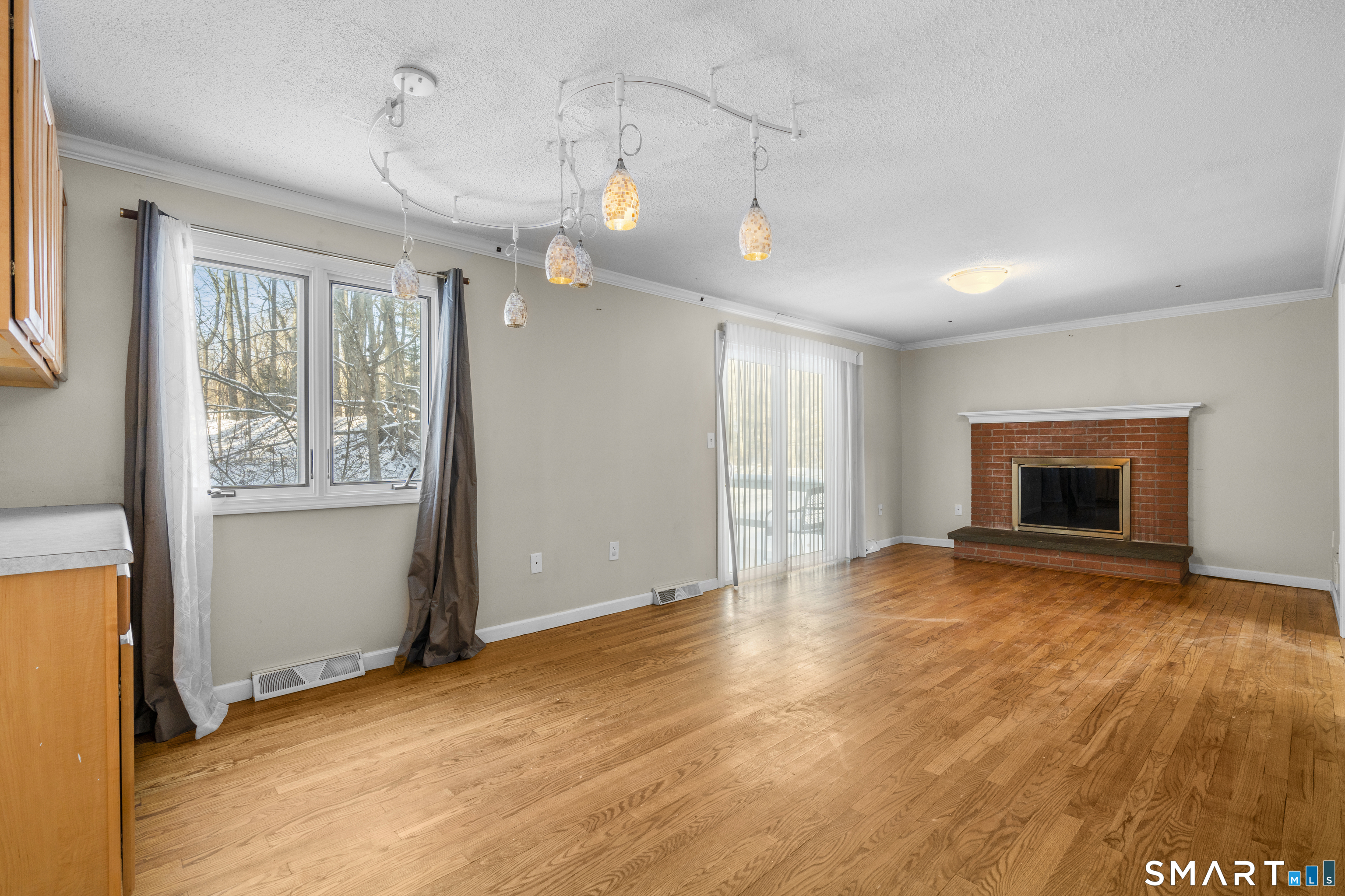 52 Laura Road Hamden, CT 06514 - Photo 9 of 35 a view of empty room with wooden floor and fireplace