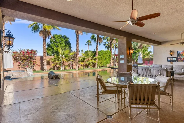 a view of a swimming pool with lawn chairs under an umbrella