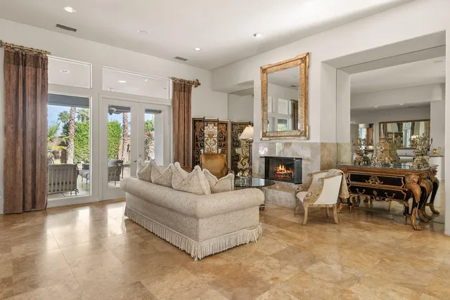 a living room with furniture a large window and a fireplace
