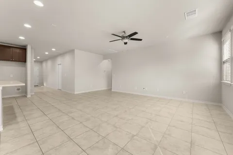 an empty room with kitchen view and a window