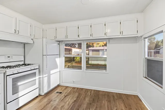 a kitchen with granite countertop white cabinets and stainless steel appliances