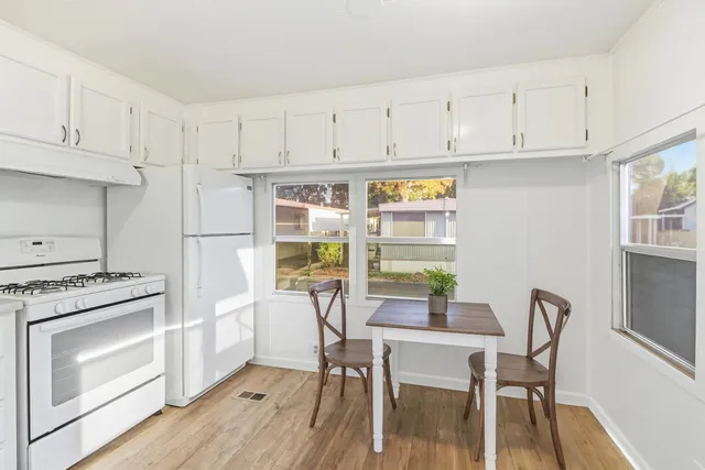 a kitchen with stainless steel appliances a stove a table and chairs