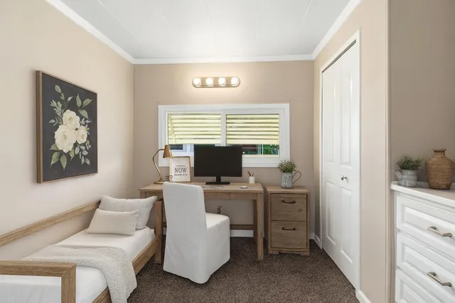 a view of a workspace with furniture and a window