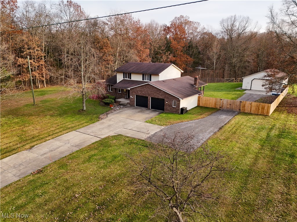 8359 Gibson Road Canfield, OH 44406 - Photo 25 of 27 View of front of property featuring a garage, brick siding, driveway, and a forest view