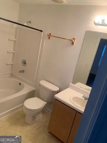 a white toilet sitting next to a bath tub a sink and a shower