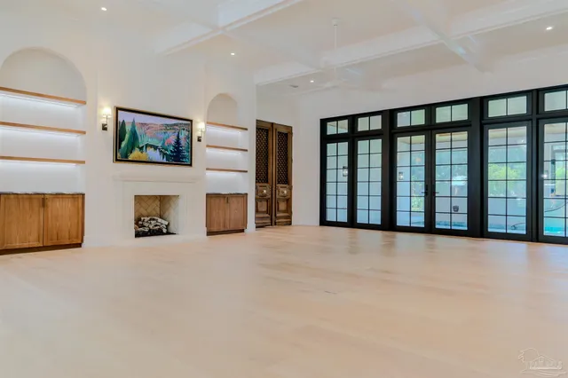 a view of an empty room with a fireplace and a window