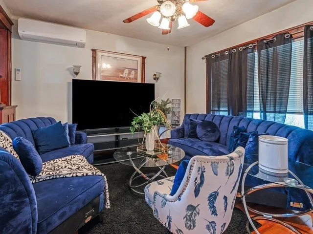 a living room with furniture a flat screen tv and a large window