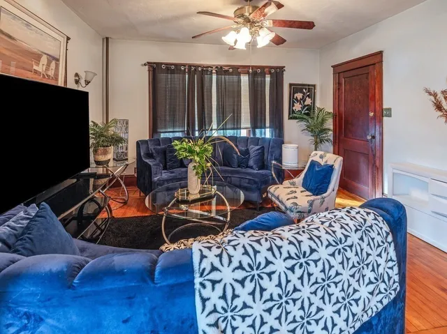a living room with furniture and wooden floor