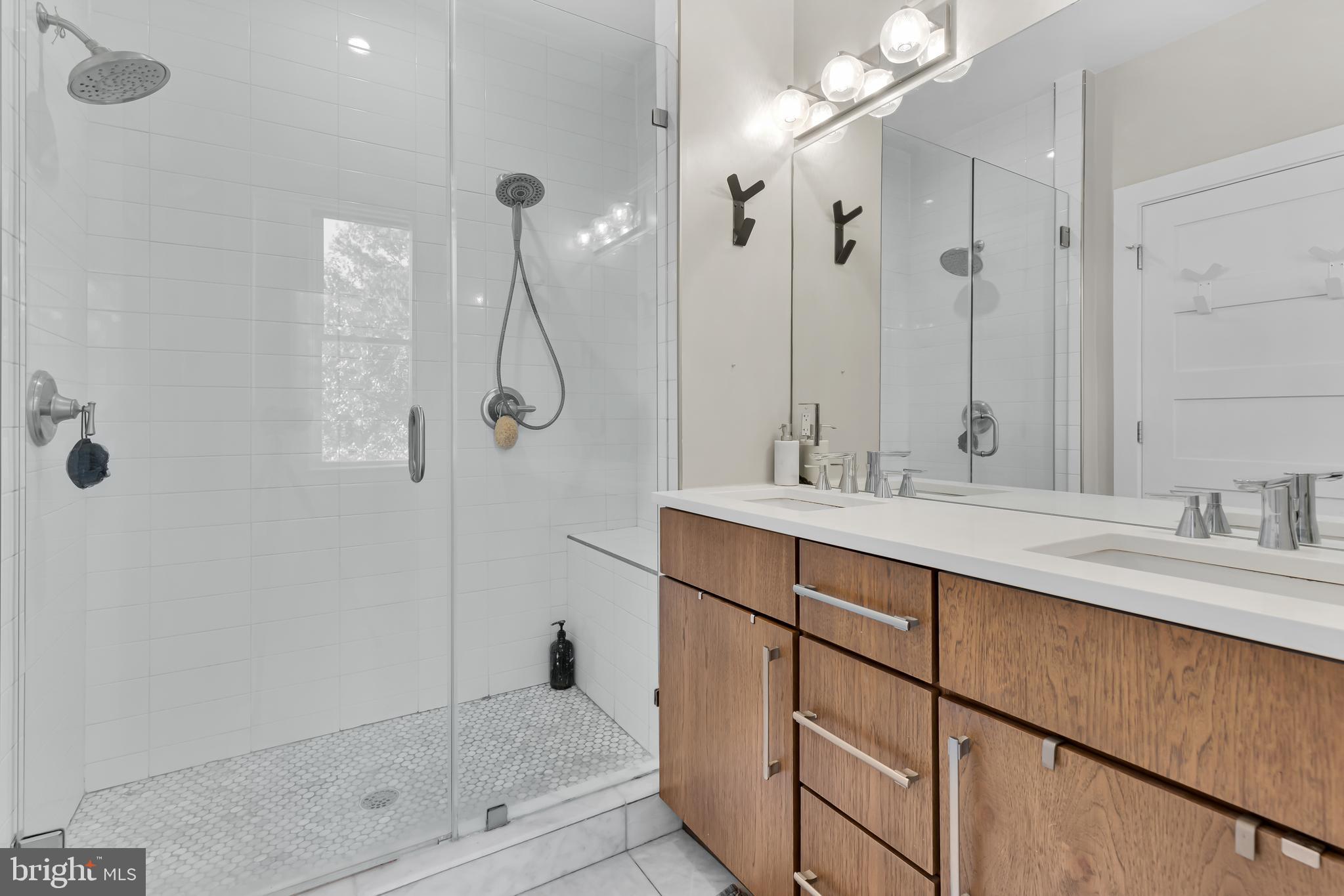 963 14th Street Southeast, Unit 1 Washington, DC 20003 - Photo 8 of 12 a bathroom with a shower sink and mirror