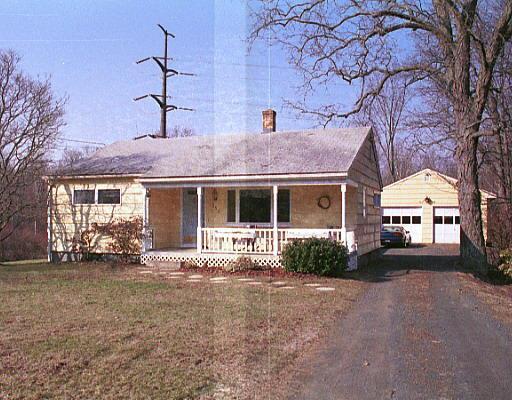 a front view of a house with a garden and trees