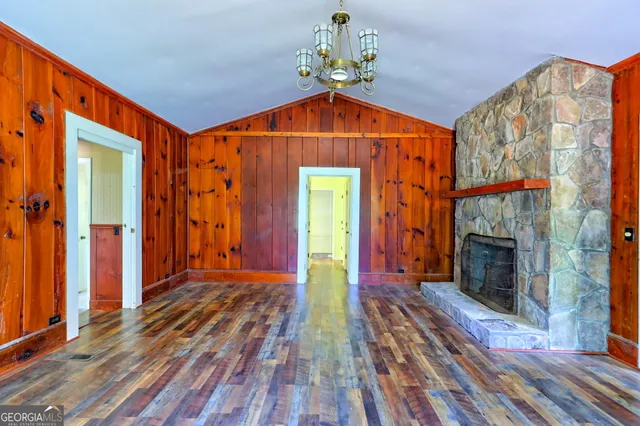 a view of a room with wooden floor and a ceiling fan