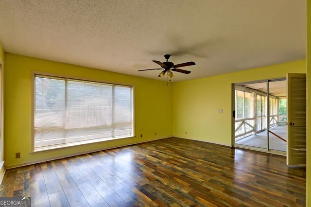 a hallway with wooden floor fireplace and windows