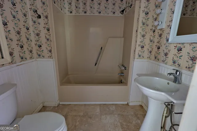 a bathroom with a toilet and a shower curtain