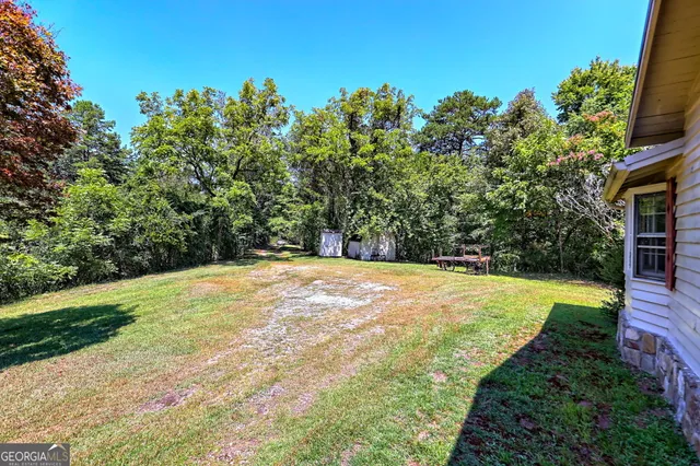 a view of a house with a small yard and wooden fence