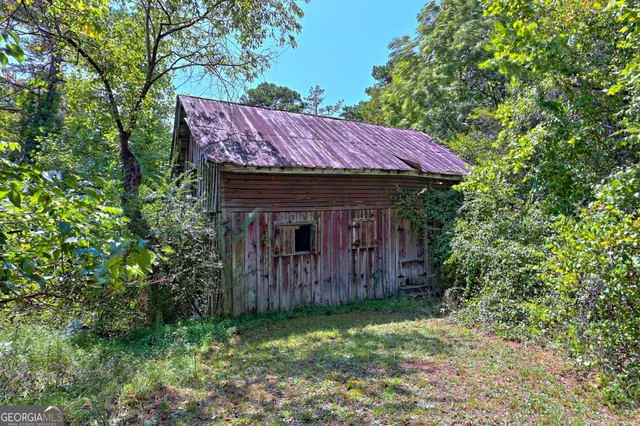 a view of a lush green forest with a house