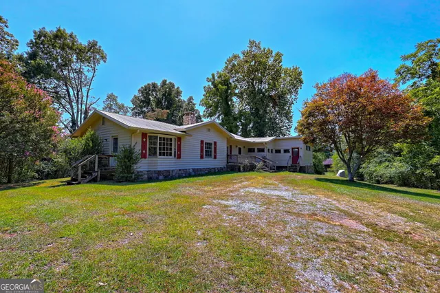 a front view of house with yard and trees in the background