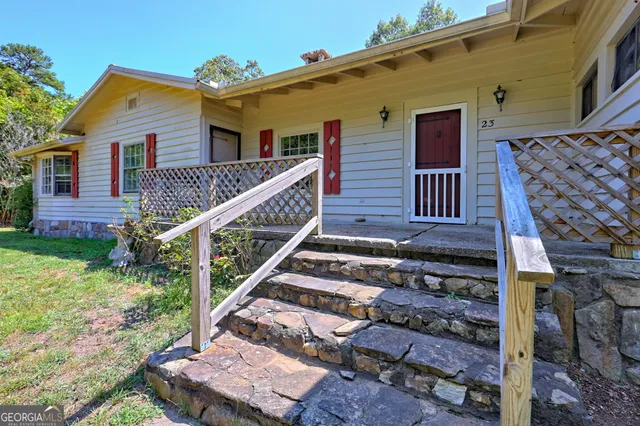 a view of a house with wooden deck and furniture