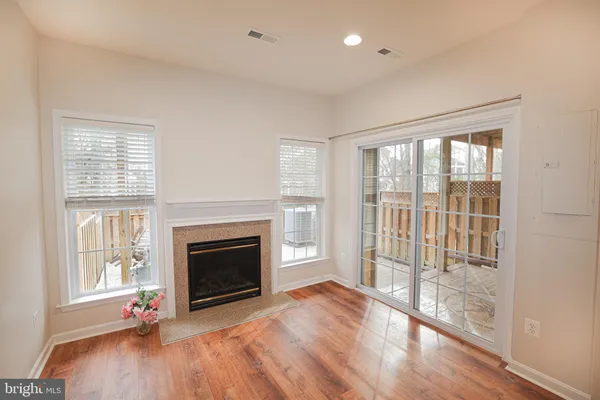 wooden floor fireplace and windows in an empty room