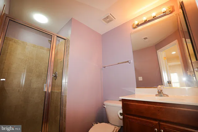 a bathroom with a sink a toilet a mirror and shower