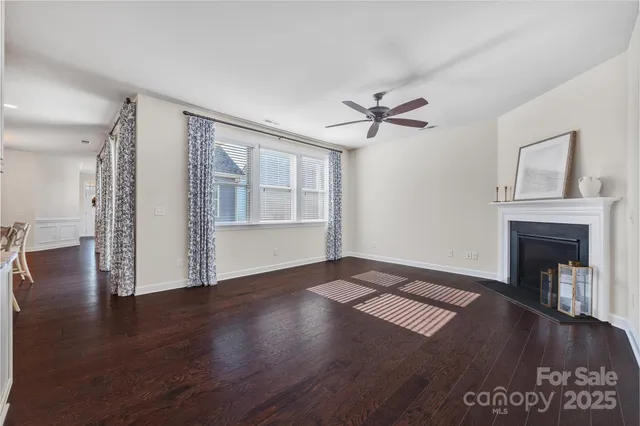a view of an empty room with wooden floor and a fireplace