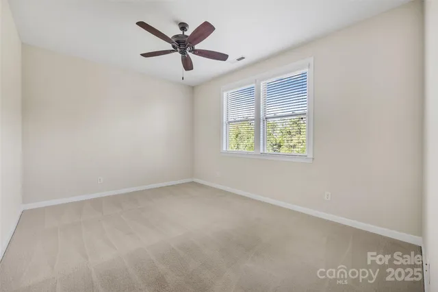 an empty room with a window and a ceiling fan