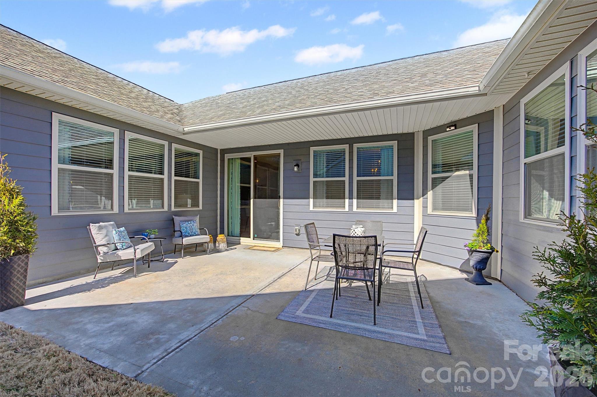 1268 Independence Street Tega Cay, SC 29708 - Photo 25 of 38 a patio with a table and chairs and potted plants