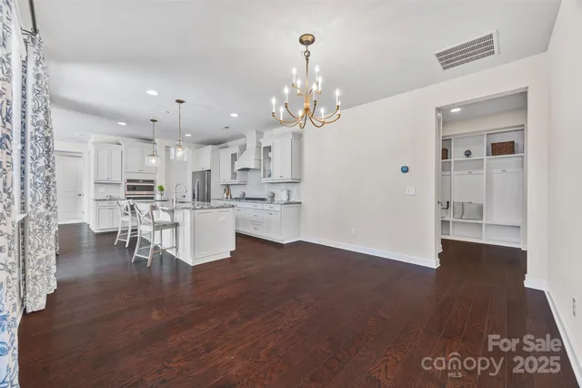 a view of a kitchen with dining table chairs wooden floor and a kitchen view