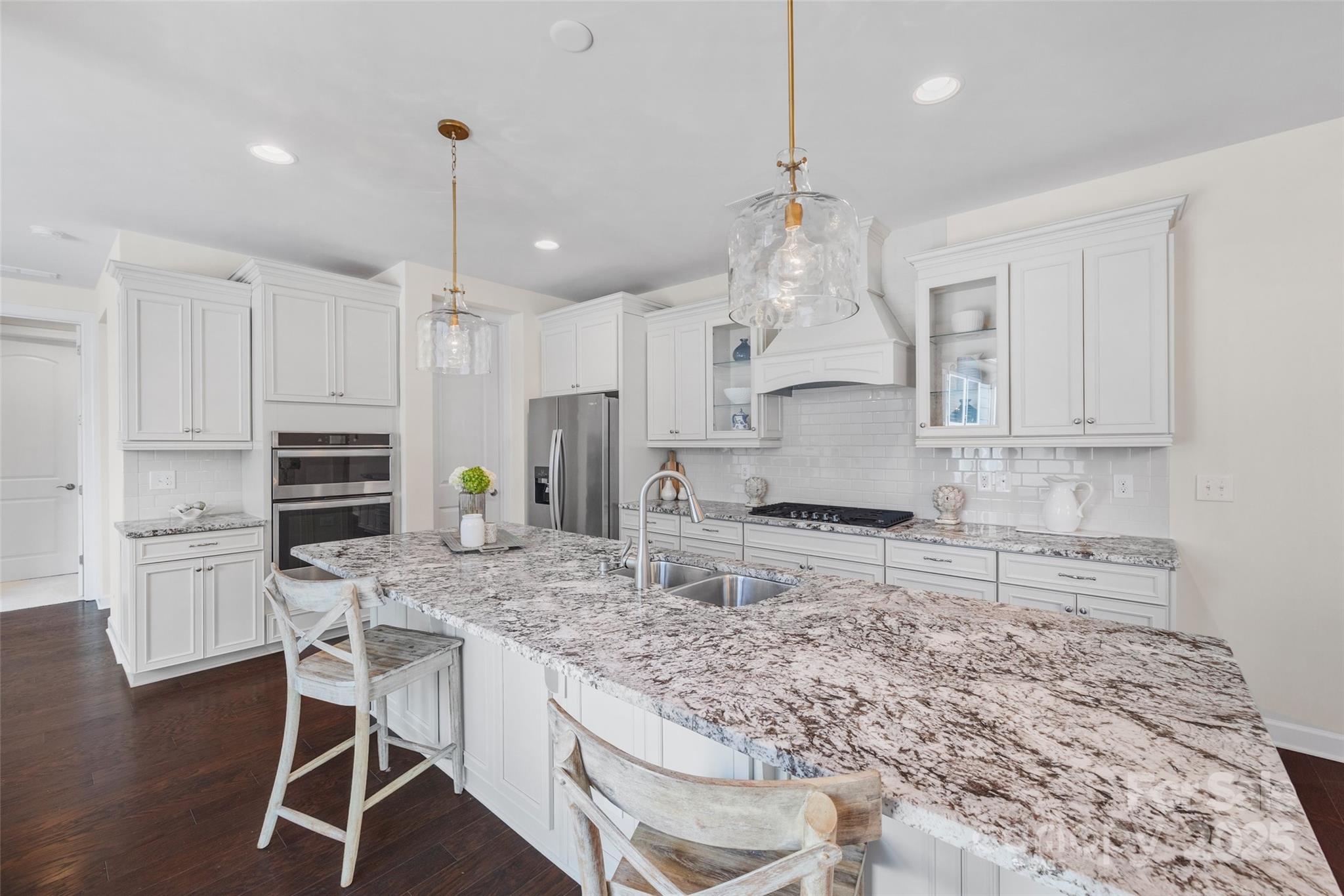 1268 Independence Street Tega Cay, SC 29708 - Photo 8 of 29 a kitchen with kitchen island granite countertop a stove a sink a oven and a refrigerator with wooden floor
