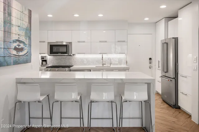 a kitchen with stainless steel appliances kitchen island granite countertop a refrigerator and a stove top oven