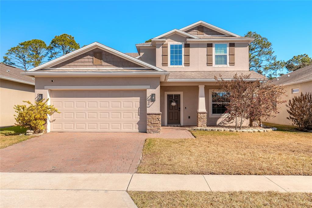 1215 Cap Diville Avenue Port Orange, FL 32129 - Photo 1 of 58 a front view of a house with a yard and garage