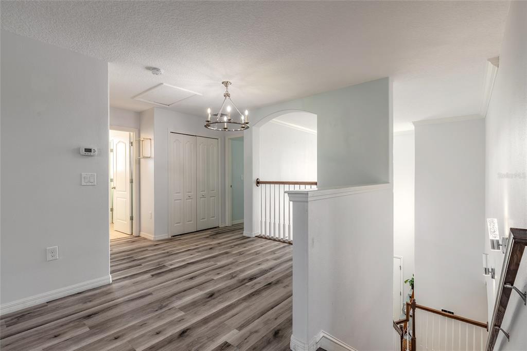 1215 Cap Diville Avenue Port Orange, FL 32129 - Photo 31 of 58 a view of a hallway with wooden floor and chandelier