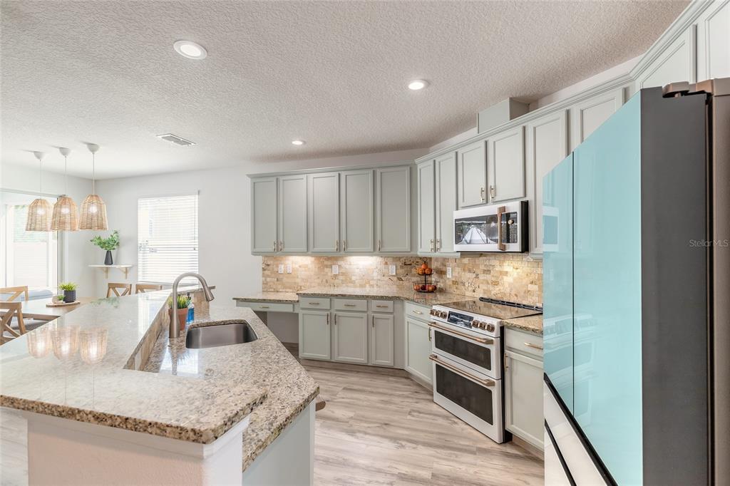 1215 Cap Diville Avenue Port Orange, FL 32129 - Photo 5 of 58 a kitchen with stainless steel appliances granite countertop a sink stove and refrigerator