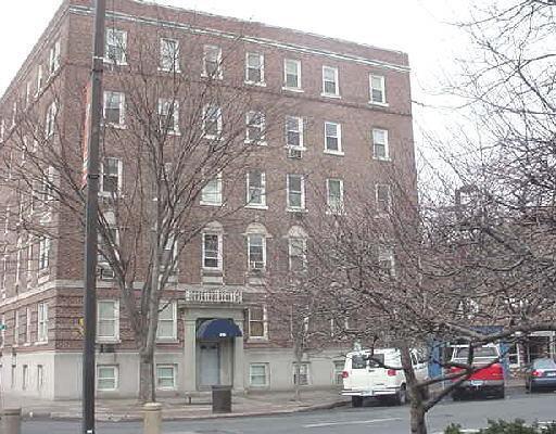 218 Bedford Street, Unit 4F Stamford, CT 06901 - Photo 1 of 1 a front view of a building with lot of cars and trees