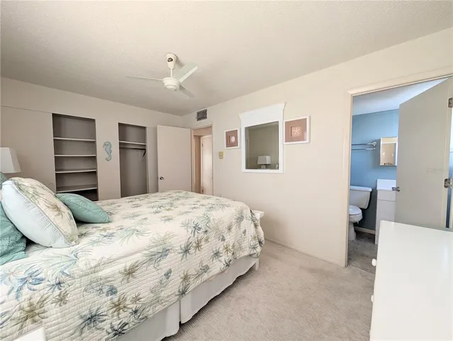 a bedroom with a bed and a refrigerator