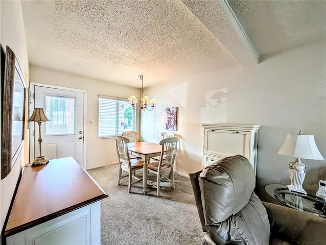 a living room with furniture a lamp and a dining table with wooden floor