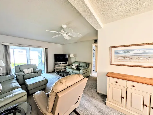 a living room with furniture a flat screen tv and a window