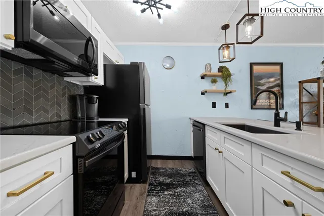 a kitchen with granite countertop a refrigerator stove and sink