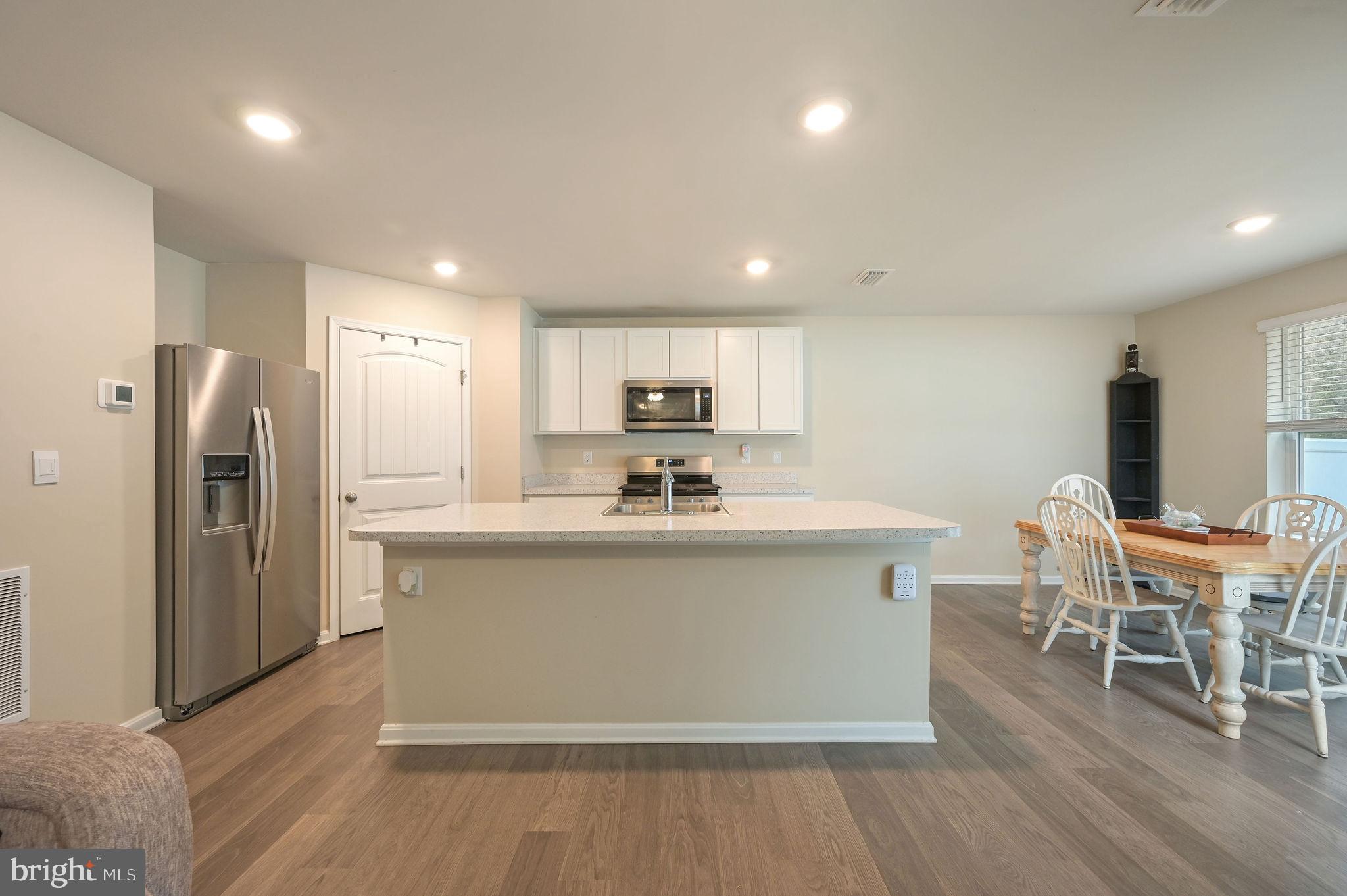504 Currant Circle Magnolia, DE 19962 - Photo 5 of 27 a kitchen with stainless steel appliances a kitchen island hardwood floor sink and cabinets